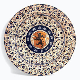 Plato con león heráldico y cenefa geométrica floral en reflejo metálico