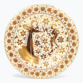 Plato de reflejo metálico sobre danza medieval entre flores y dorados